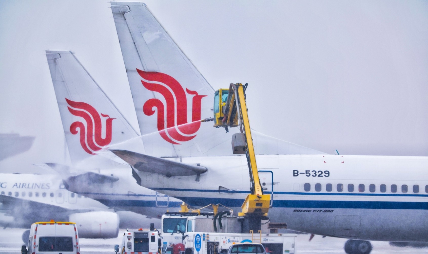 近日，寒潮席卷我国大部分地区，带来大风、降温天气，华北等地出现大范围雨雪，给航空出行保障带来挑战。中航集团各岗位工作人员迎风斗雪、高效联动，全力保障旅客安全出行。图为北京首都国际机场工作人员进行除冰雪作业。 