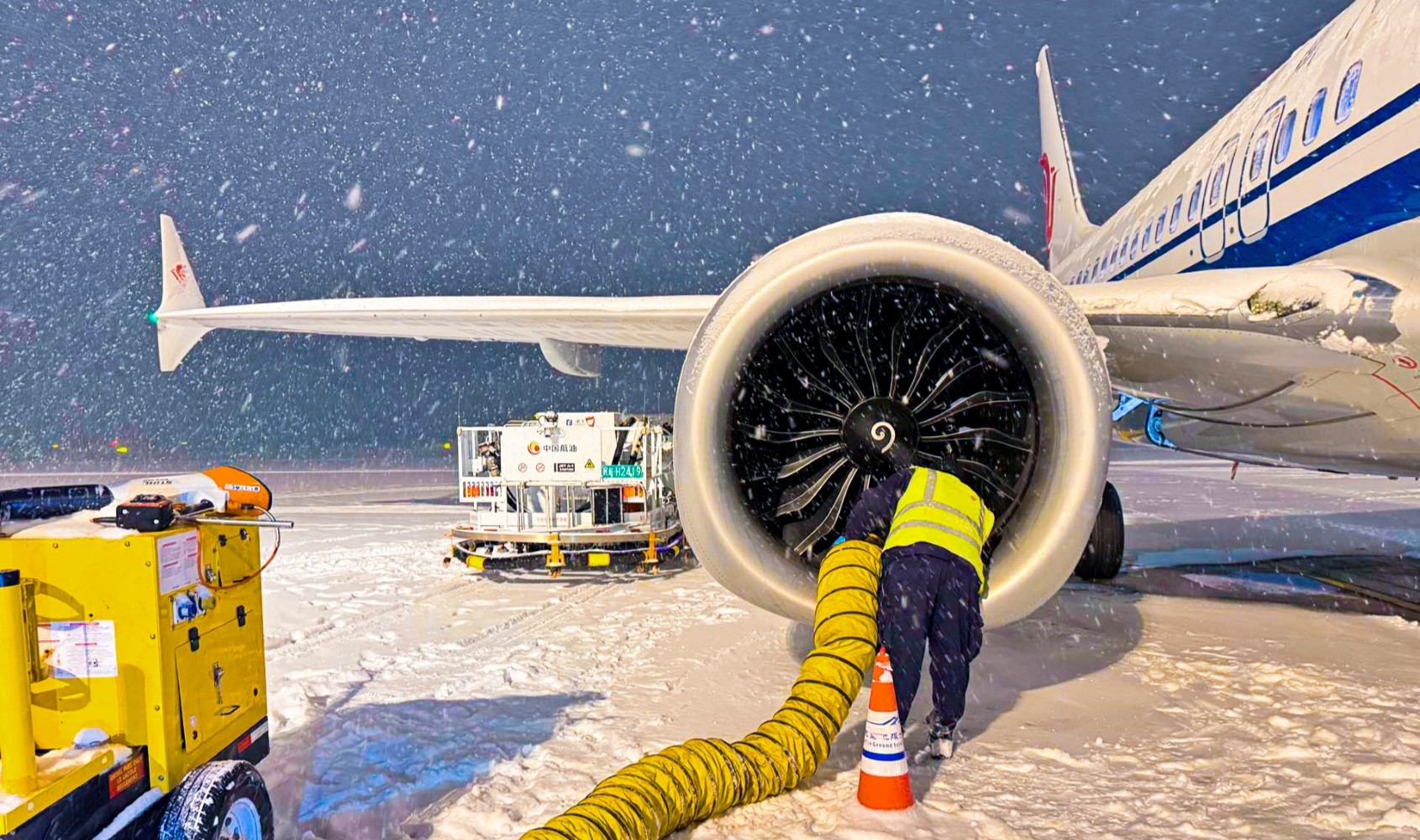在乌鲁木齐天山国际机场，中航集团机务人员进行除冰雪作业。 