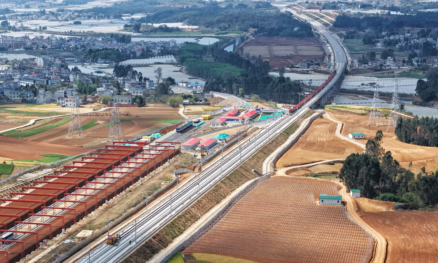 近日，在云南省昆明市渝昆高铁施工现场，随着中铁十六局铺轨机的精准作业，第一对500米长钢轨稳稳落在无砟轨道上，渝昆高铁云南段正式开始铺轨。图为建设中的渝昆高铁。
